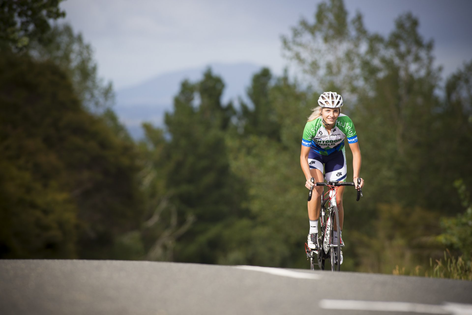 Female cyclist making her way uphill, solo